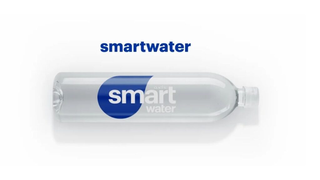 A bottle of smartwater 9.5+pH. The label highlights alkaline with antioxidants. Vapor distilled ionized water beverage with antioxidants selenium and electrolytes. 12 FL OZ (355mL) 

The blue water bottle label highlights vapor distilled water and electrolytes for taste. 12 FL OZ (355mL)