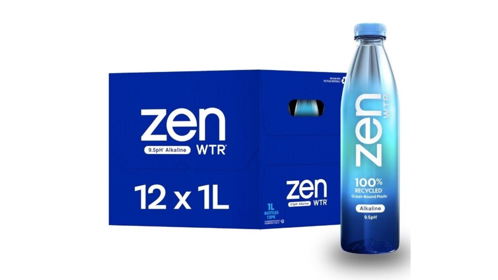 A women in a gray outer carrying a bottle of zen water. The water bottle label highlights 100% Recycled Ocean Sound Plastic. Alkaline 8.5pH. 